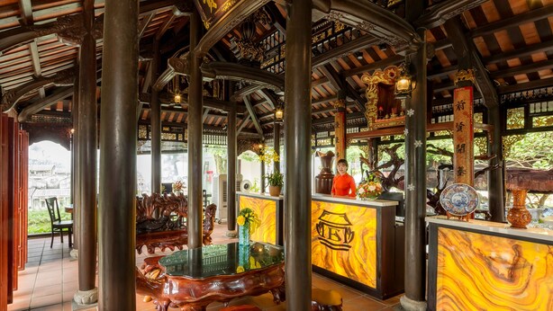 A traditional wooden structure with ornate carvings and a tiled floor. - Hoi An Emotion Boutique Villa (Da Nang)