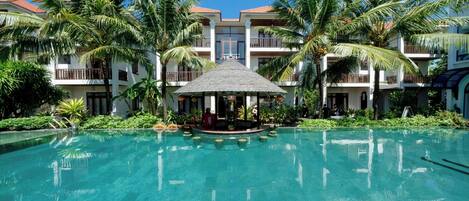 Alberca al aire libre, sombrillas en la alberca y camastros