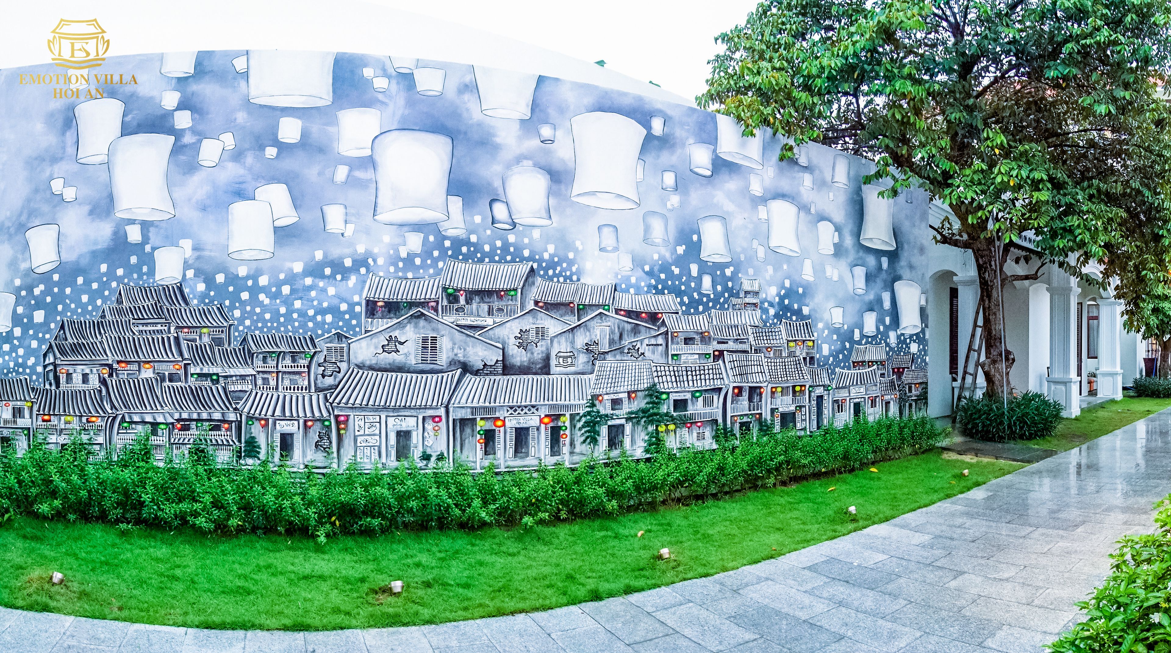A mural of traditional buildings with lanterns, a tree, and a pathway.