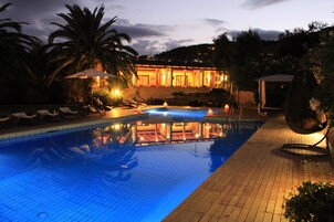 Una piscina al aire libre de temporada, sombrillas