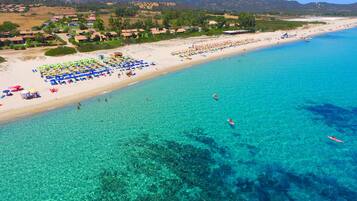 On the beach, white sand, sun-loungers, beach umbrellas