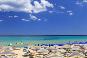 Plage, sable blanc, chaises longues, parasols