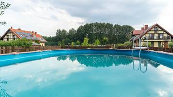Relax by the serene pool surrounded by traditional European-style houses with gabled roofs.