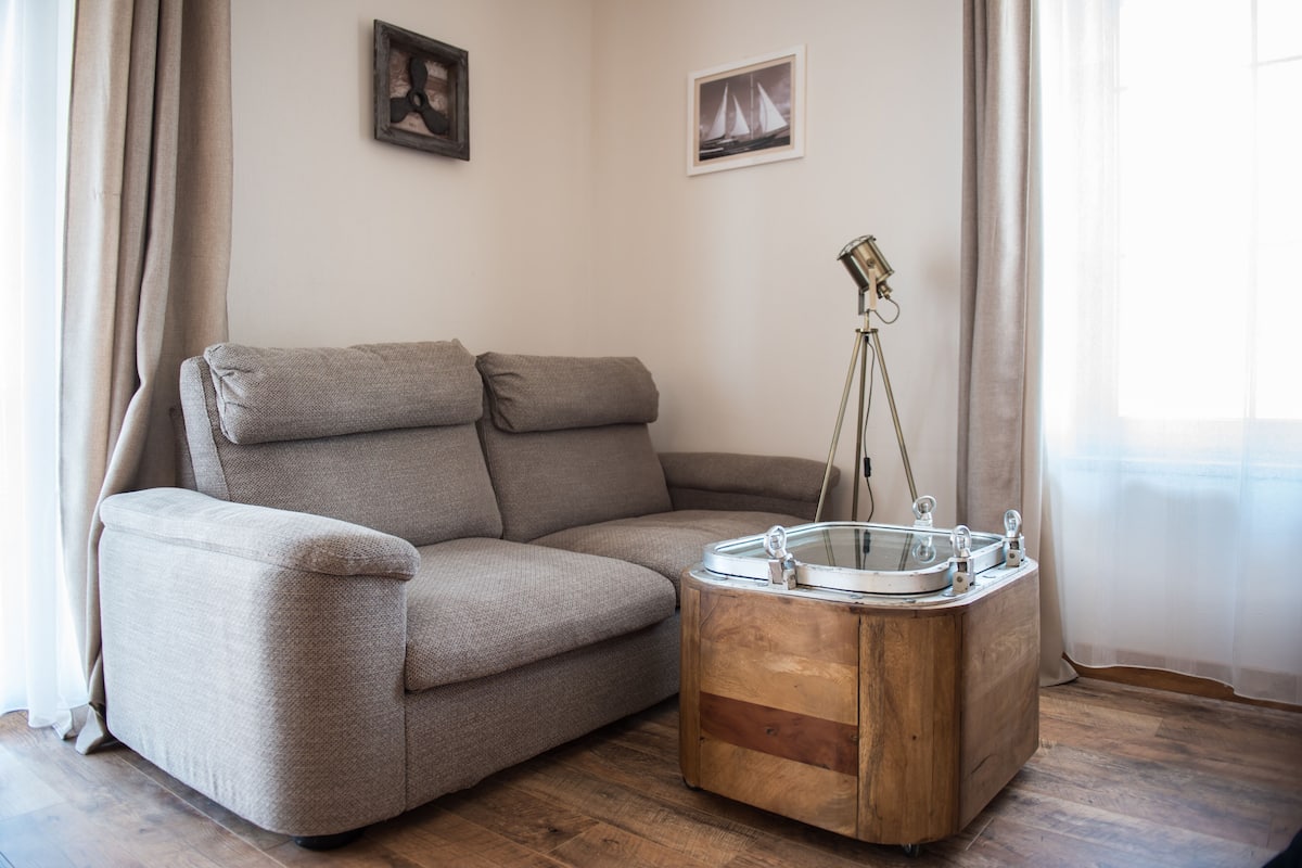 A modern living room with a beige sofa, a wooden coffee table, and a floor lamp.