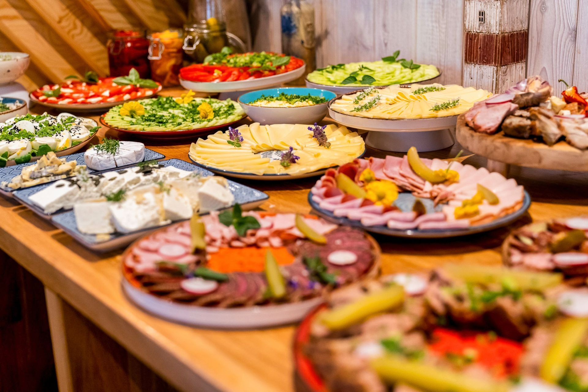 Un buffet proposant une variété de plats, notamment des fromages, des viandes et des salades.