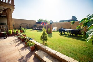 A backyard with a patio, outdoor furniture, and potted plants. - Welcomheritage Ranjit Vilas (Amritsar)