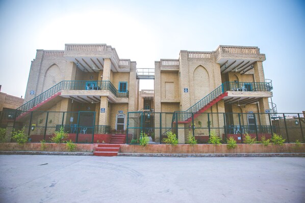 A two-story building with a central staircase, a covered entrance, and a fenced courtyard. - Welcomheritage Ranjit Vilas (Amritsar)