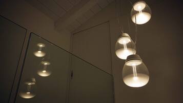 A bathroom with a mirror and pendant lights.