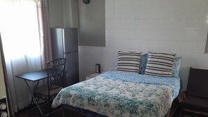 A bedroom with a bed, a desk, a chair, and a TV. - Mambilima Furnished Guest Wing (Lusaka)