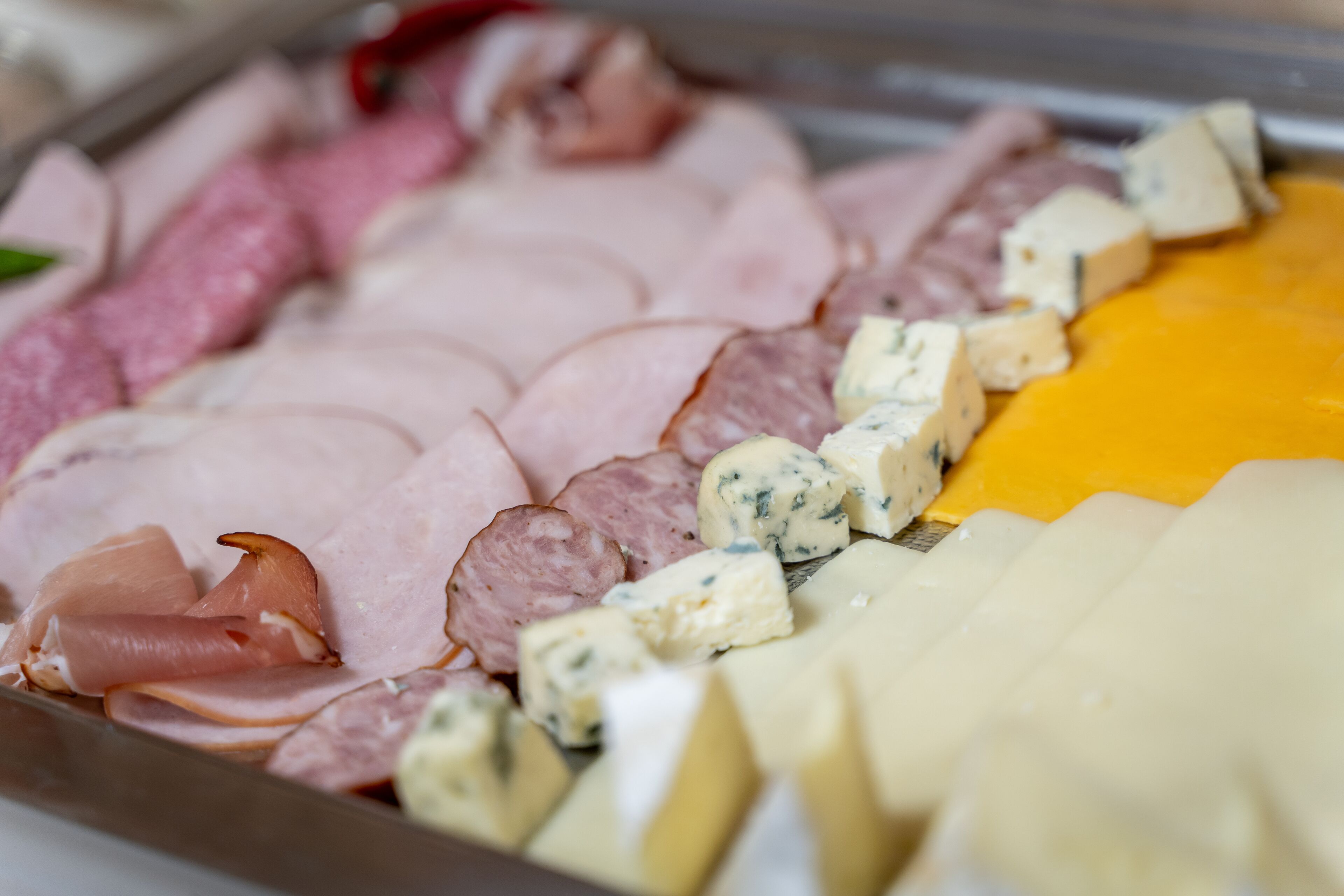 A charcuterie board with various meats and cheeses.