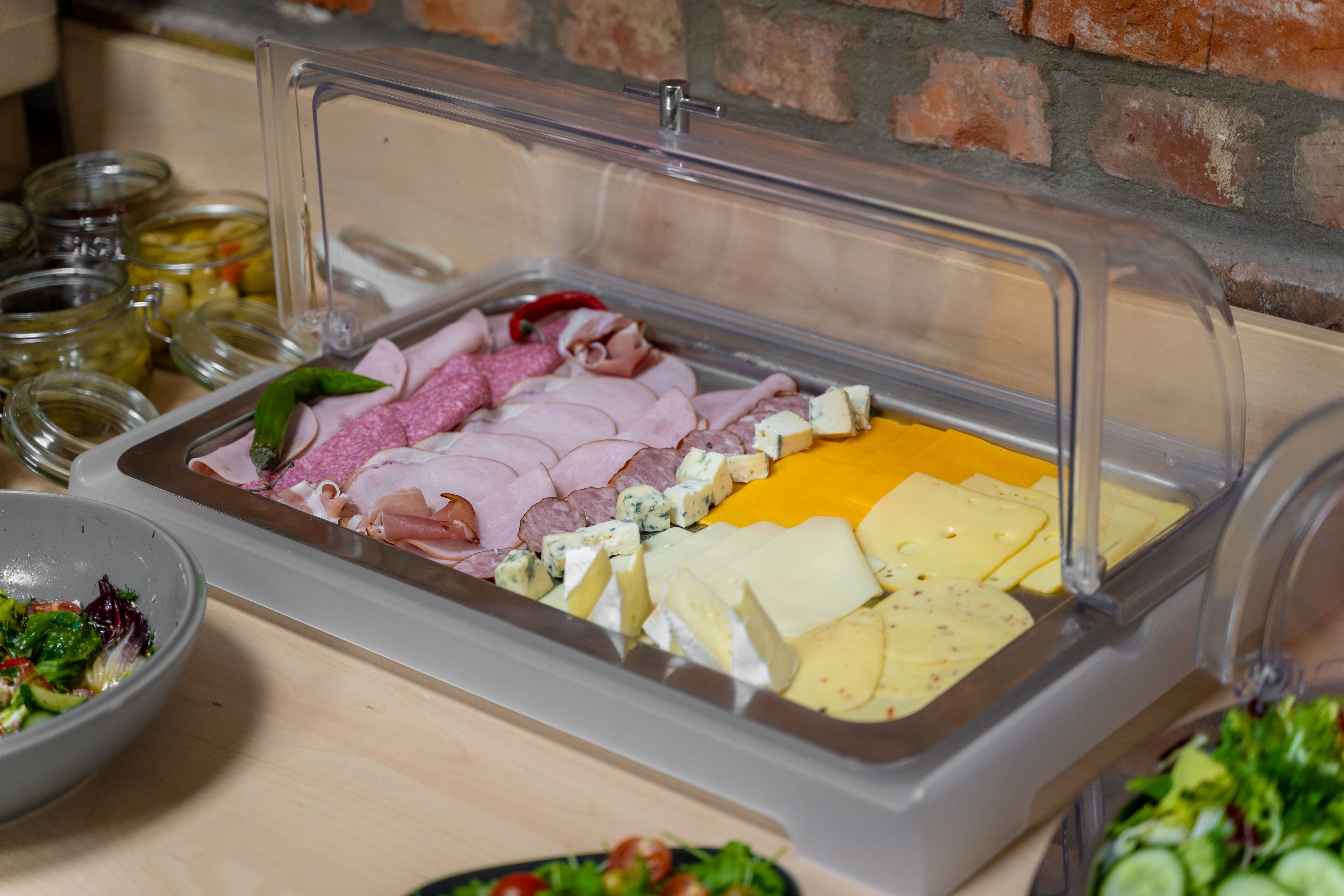 Buffet com diversos tipos de carne, queijos e legumes em conserva.
