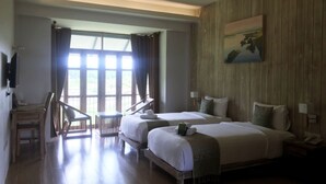 A hotel room with two beds, a wooden wall, a painting, and a view through large windows. - Nansripanna Resort (Nan)
