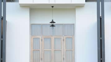 A building with a balcony, a table with chairs, and air conditioning units.