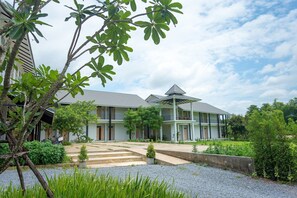 A modern two-story house with a covered porch and a well-maintained garden. - Nansripanna Resort (Nan)