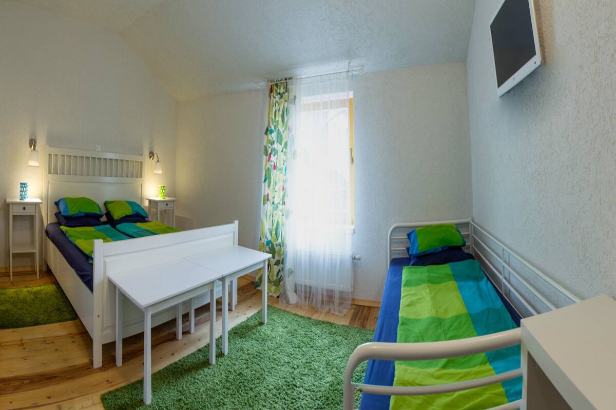 Un dormitorio con dos camas, un escritorio y un televisor.