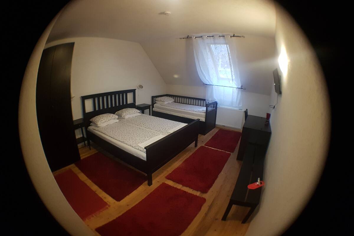 Un dormitorio con dos camas, un escritorio y una ventana con cortinas.