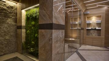 Experience the seamless blend of natural and artificial lighting in this inviting space, featuring a glass elevator and polished stone tiles.