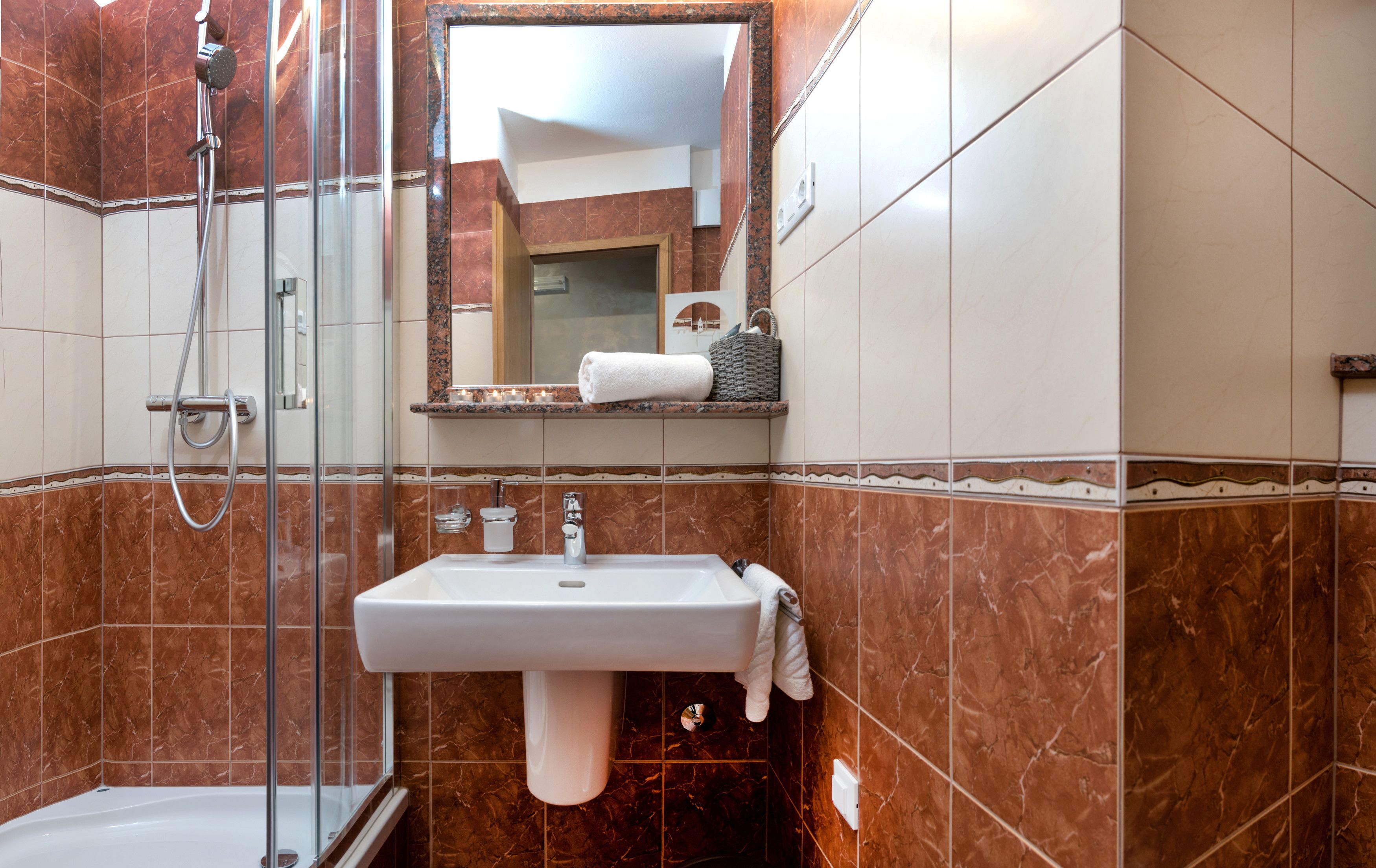 Un baño con lavabo, espejo y ducha.