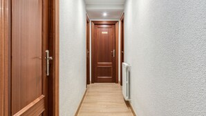 A hallway with wooden doors and a radiator on the wall. - Hostal Uria (Salamanca)