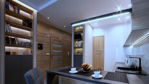 Una cocina moderna con comedor, armarios de madera y estanterías empotradas.
