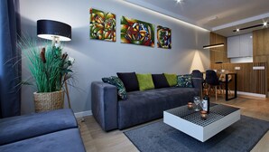 Ett modernt vardagsrum med en grå soffa, ett soffbord och en matplats med ett träbord och stolar.