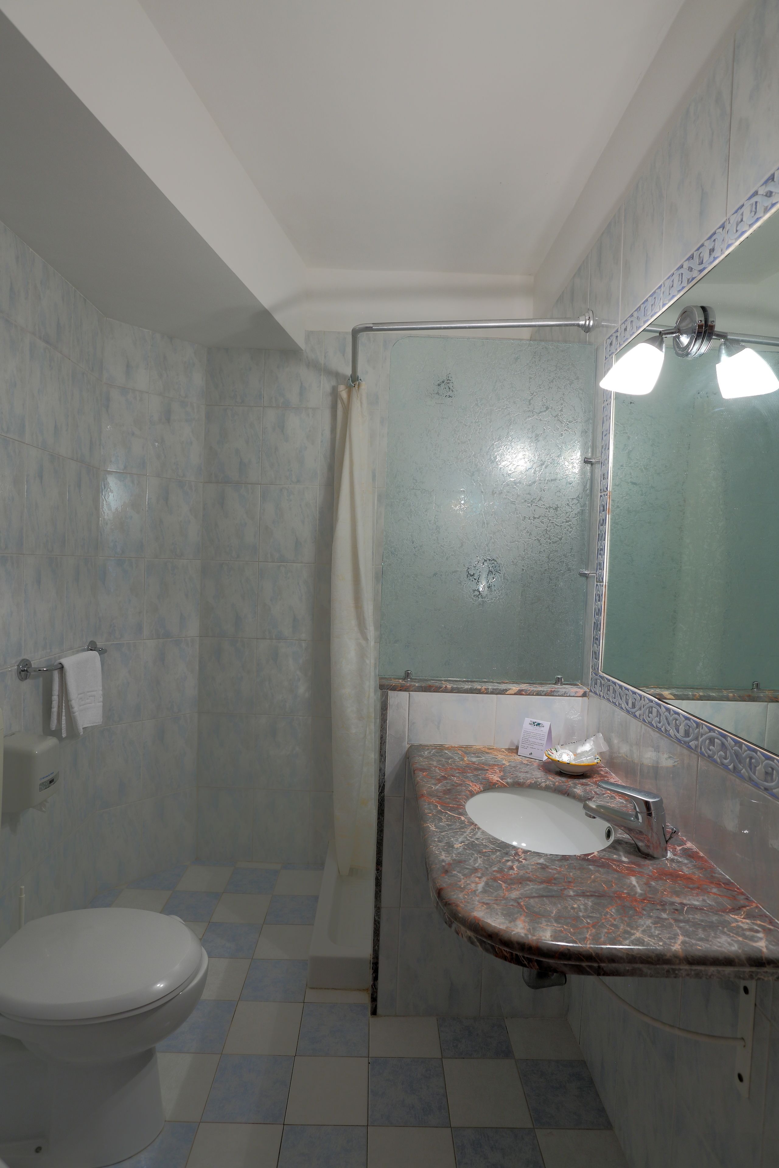 Een badkamer met toilet, wastafel en douche.
