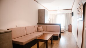 Una sala de estar moderna con un sofá modular, una mesa de centro de madera y una televisión empotrada.