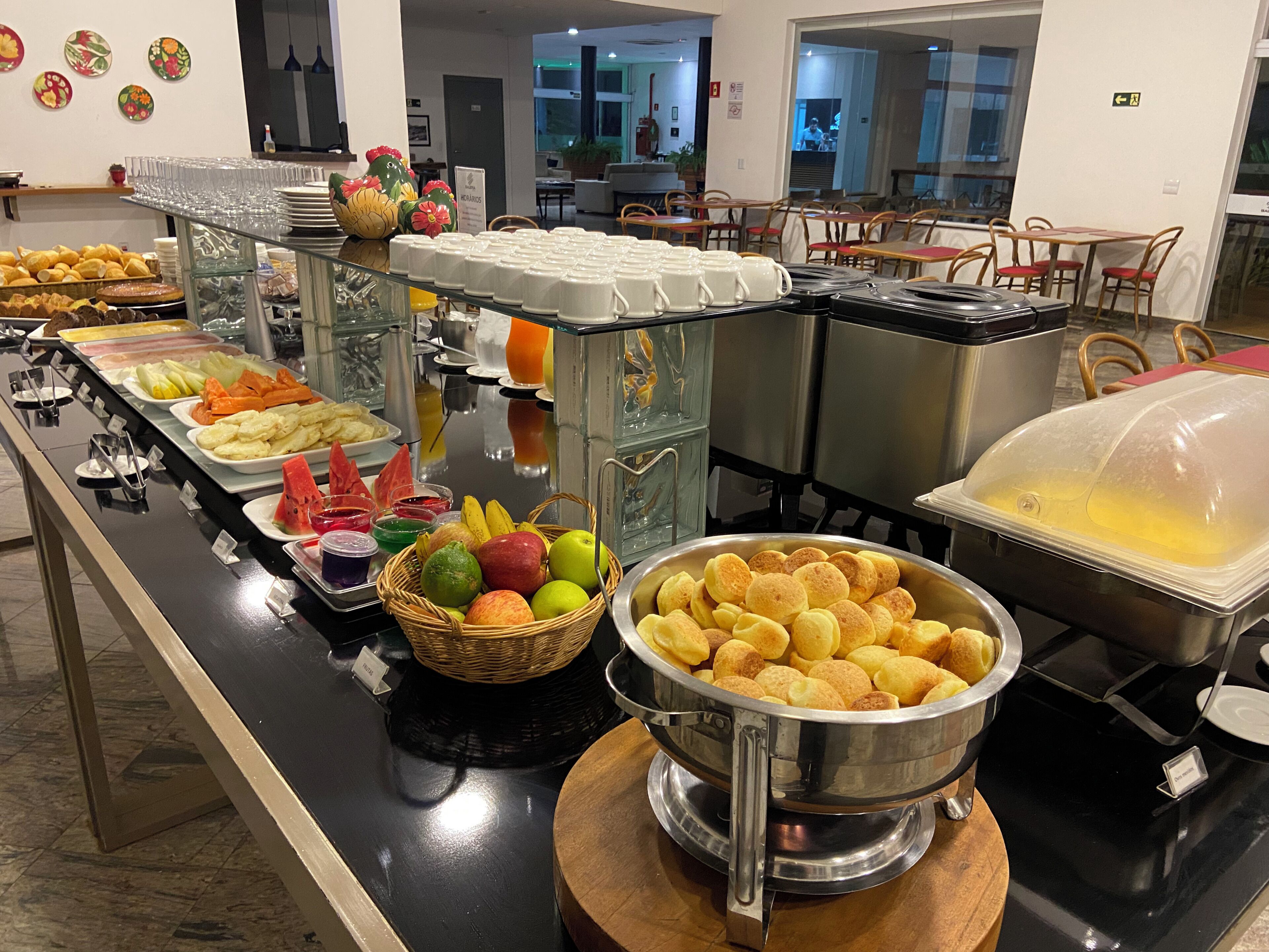Ein Buffetbereich mit verschiedenen Speisen und eine Sitzgelegenheit mit Tischen und Stühlen.