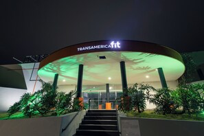 A hotel entrance with a sign reading 'TRANSAMERICAfit' and a staircase leading up to the entrance. - Transamerica Fit Jaú (Jau)