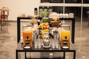 Mesa de buffet com diversos alimentos e bebidas.