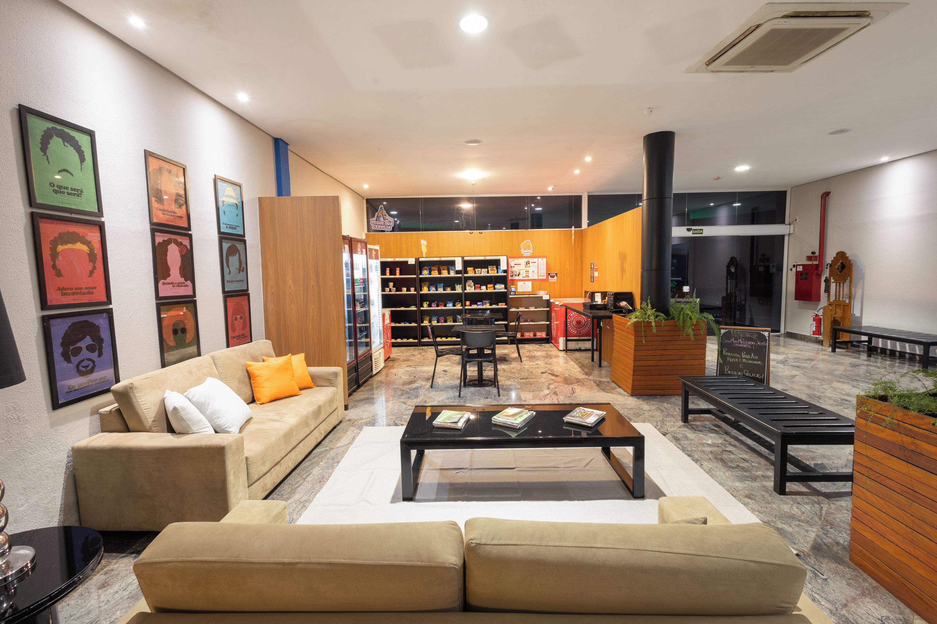 Un moderno espacio de descanso con un sofá, una mesa de centro y una estantería llena de aperitivos.