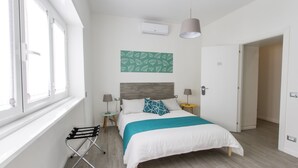 A bedroom with a bed, a window, a wall-mounted air conditioner, and a door. - FeelinRome Bed & Breakfast (Rome)