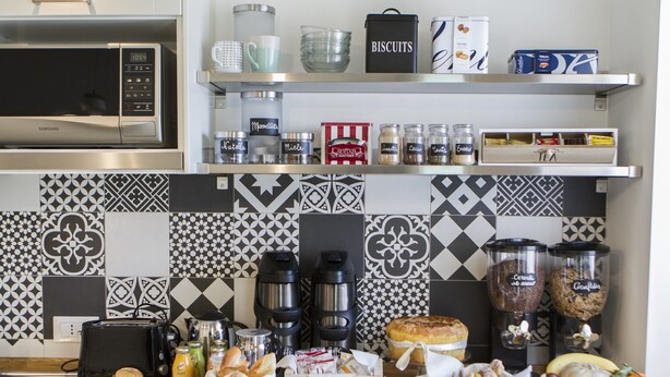 A kitchen with a microwave, toaster, and various food items on the counter. - FeelinRome Bed & Breakfast (Rome)