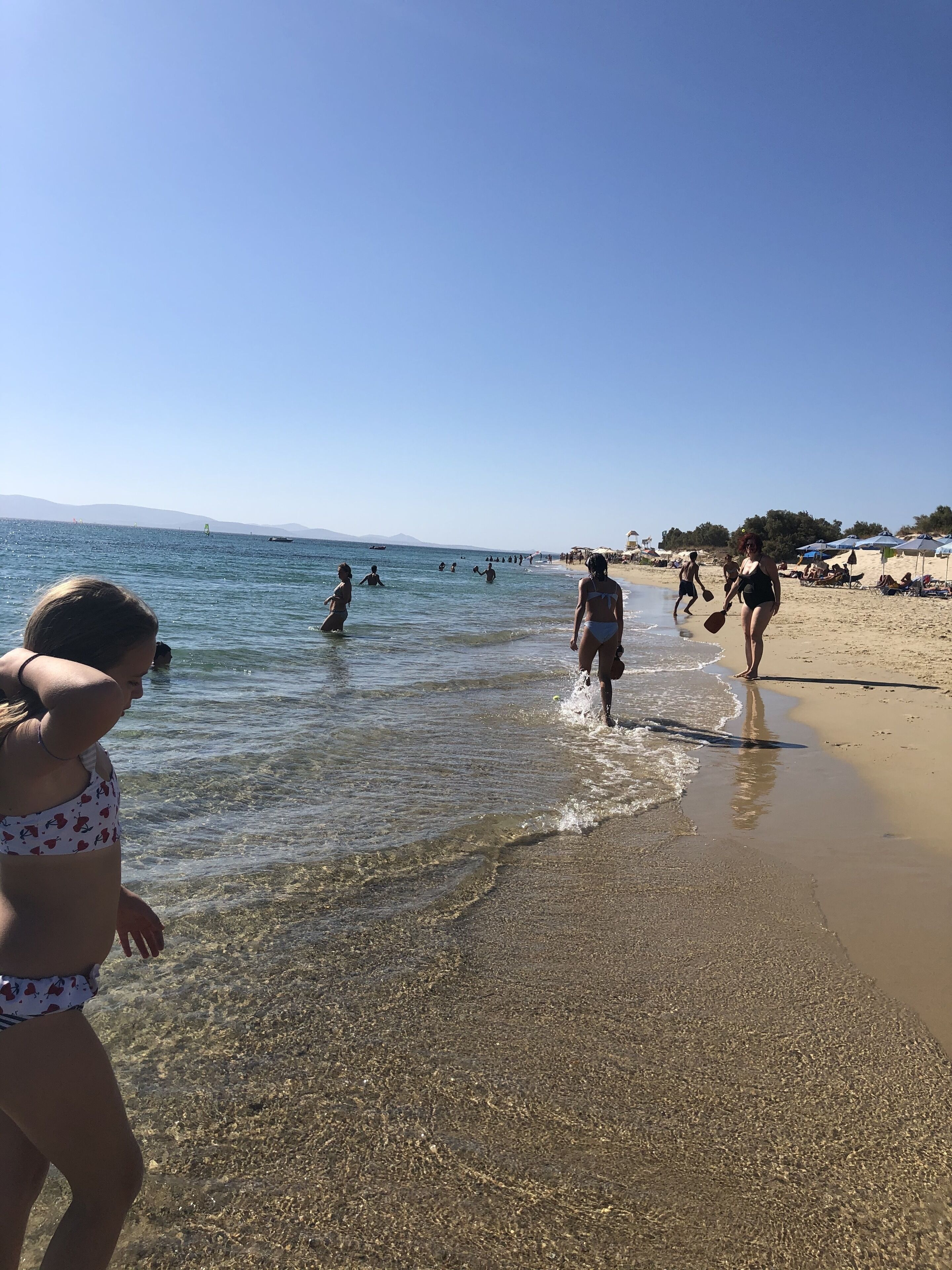 A beach scene with clear skies and calm waters.