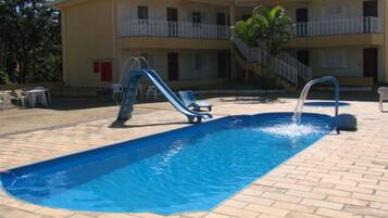 Una piscina al aire libre, tumbonas