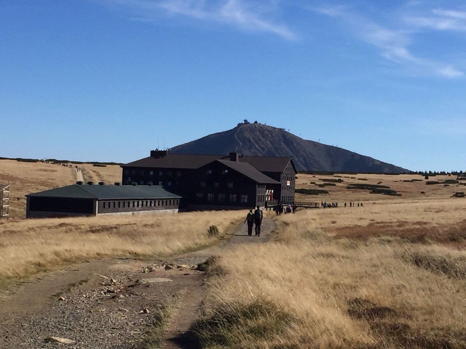 A building with a large entrance and a mountain in the background.