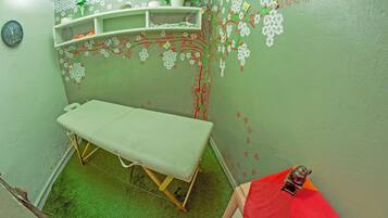 A small room with a single bed, a shelf with decorative items, and a clock on the wall.