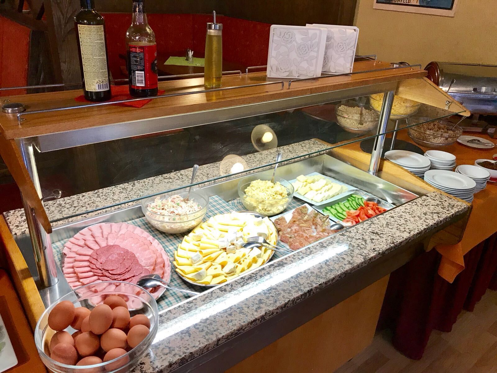 Un buffet proposant une variété de plats, notamment des œufs, de la viande et des fromages.