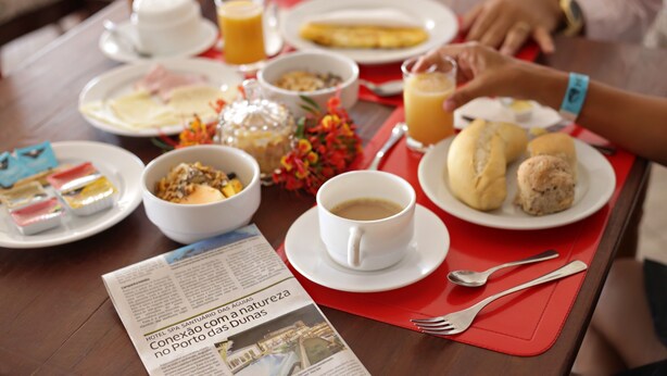 Una escena de desayuno con platos de comida, una taza de café y un menú.