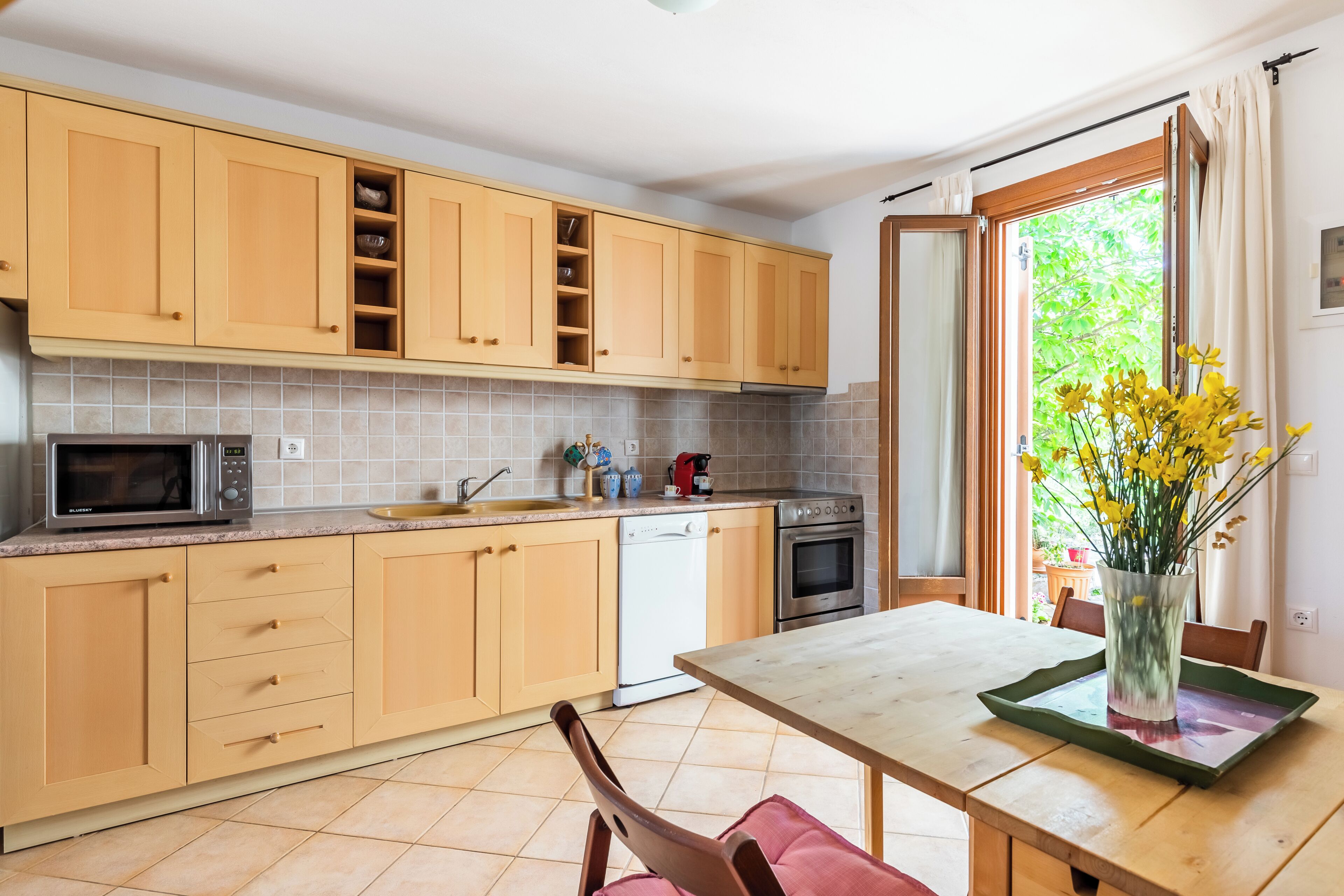 A kitchen with wooden cabinets, a microwave, a dishwasher, and an oven.