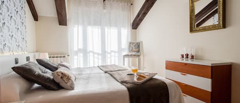 A bedroom with a bed, bedside table, dresser, and a mirror on the wall.