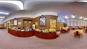 A buffet area with a variety of food items, a counter with a mirror, and multiple dining tables with chairs. - SkiHotel Lenka (Spindleruv Mlyn)