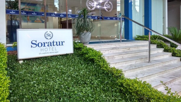 The entrance of Soratur Hotel with a signboard, glass doors, and a staircase leading up to the entrance. - Soratur Hotel & Coworking (Criciuma)