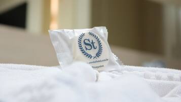 A white package with a laurel wreath logo and text on a bed.