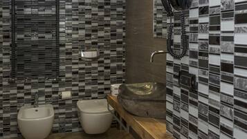 A modern bathroom with a wooden vanity, two bidets, and a large sink.