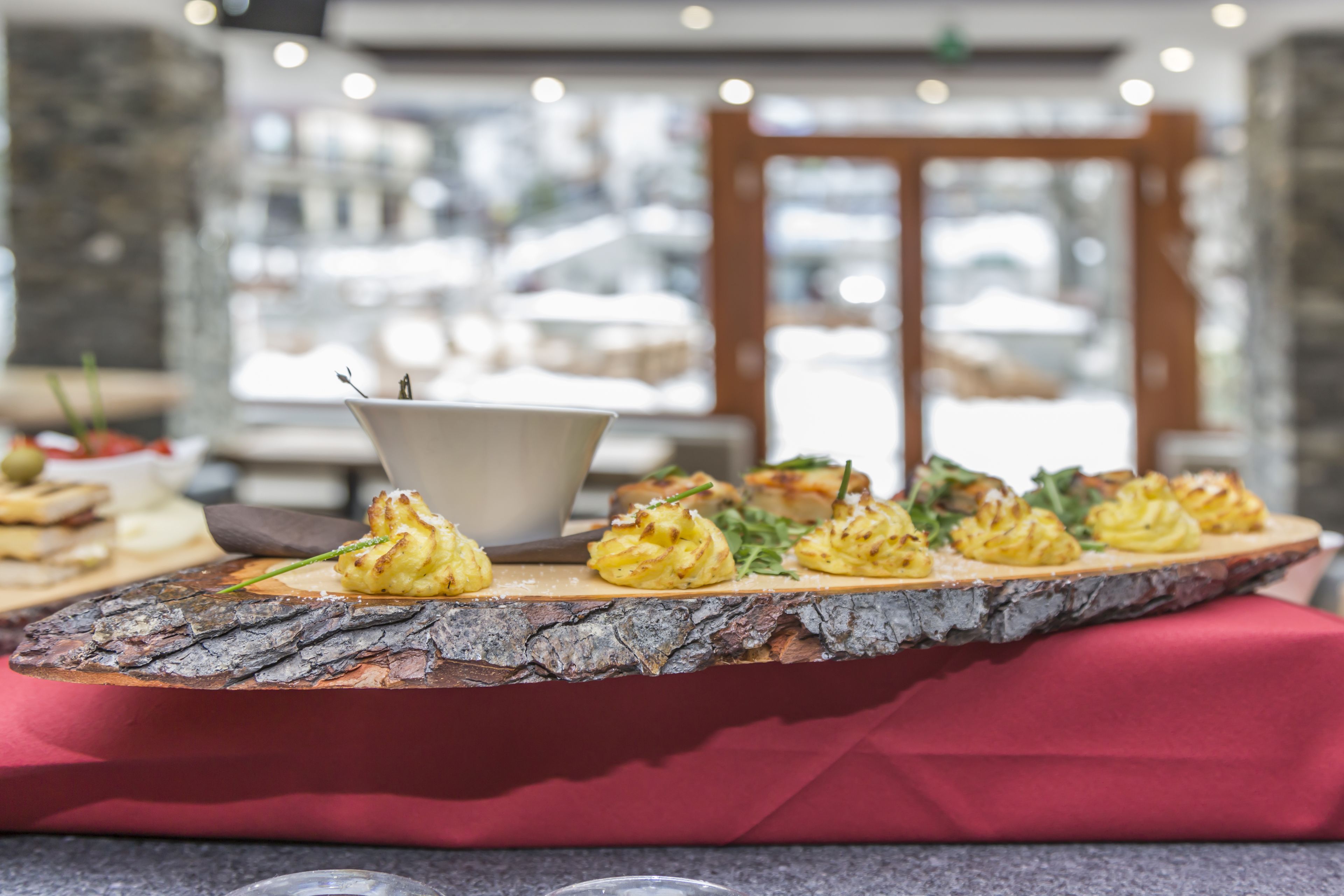A buffet table with a variety of appetizers, including puff pastry items, in a restaurant setting.