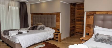 Un dormitorio moderno con dos camas, cabeceros de madera y un tapete de cuero de vaca.