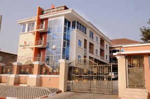 A hotel with a modern facade, large windows, and a gated entrance. - Georgetown Hotel (Abuja)