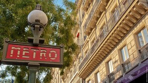 A street sign with "METRO" written on it, a lamp post, and a building with balconies. - My Home For You B&B (Paris)