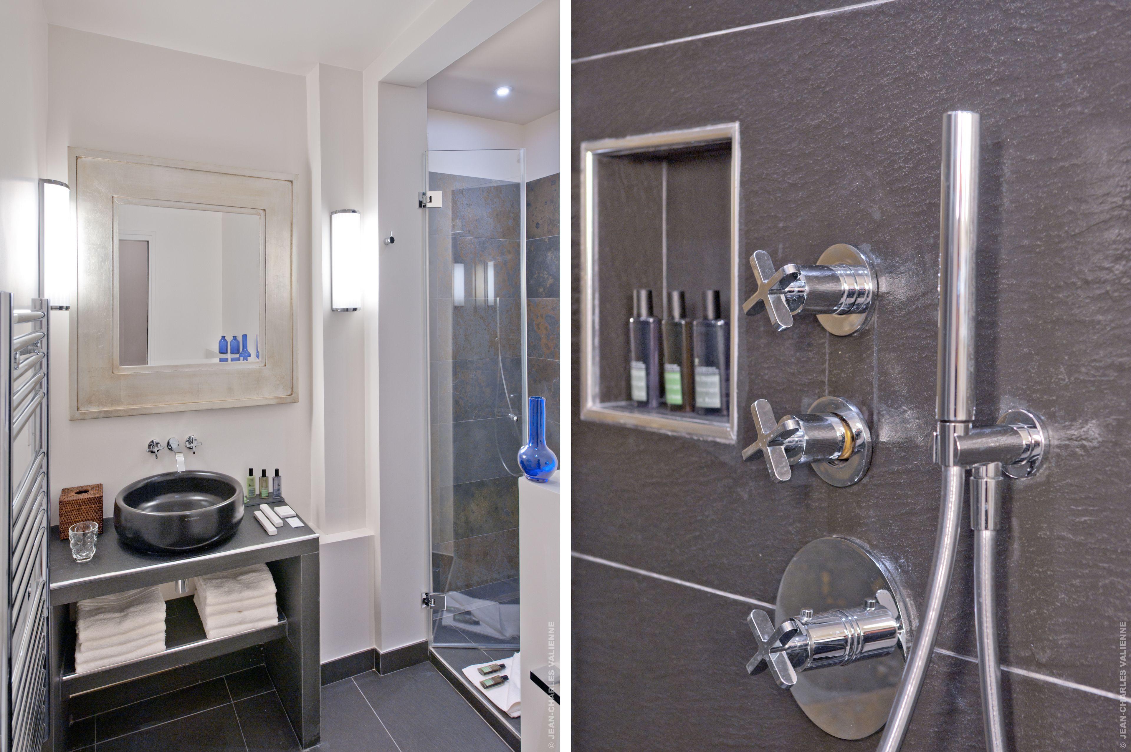 A modern bathroom with a large mirror, a round sink, and a glass-enclosed shower area.